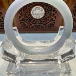 Translucent white jade bangle on stand