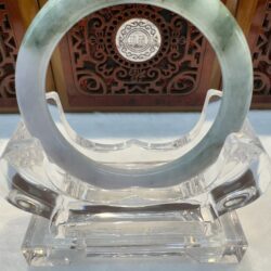 Jade bangle with carved wood backdrop