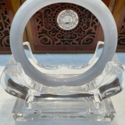 Crystal circular sculpture on ornate display stand.
