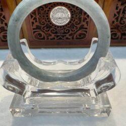 Translucent pale jade bangle on acrylic stand