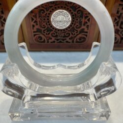 Translucent white jade bangle on clear stand