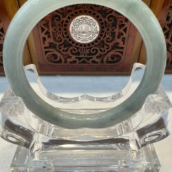 Pale green jade bangle with wooden backdrop