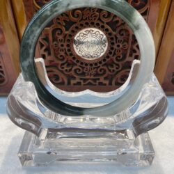 Jade ring displayed before carved wood panel