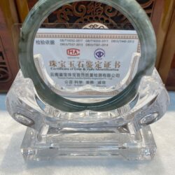 Green jade bangle displayed on clear stand